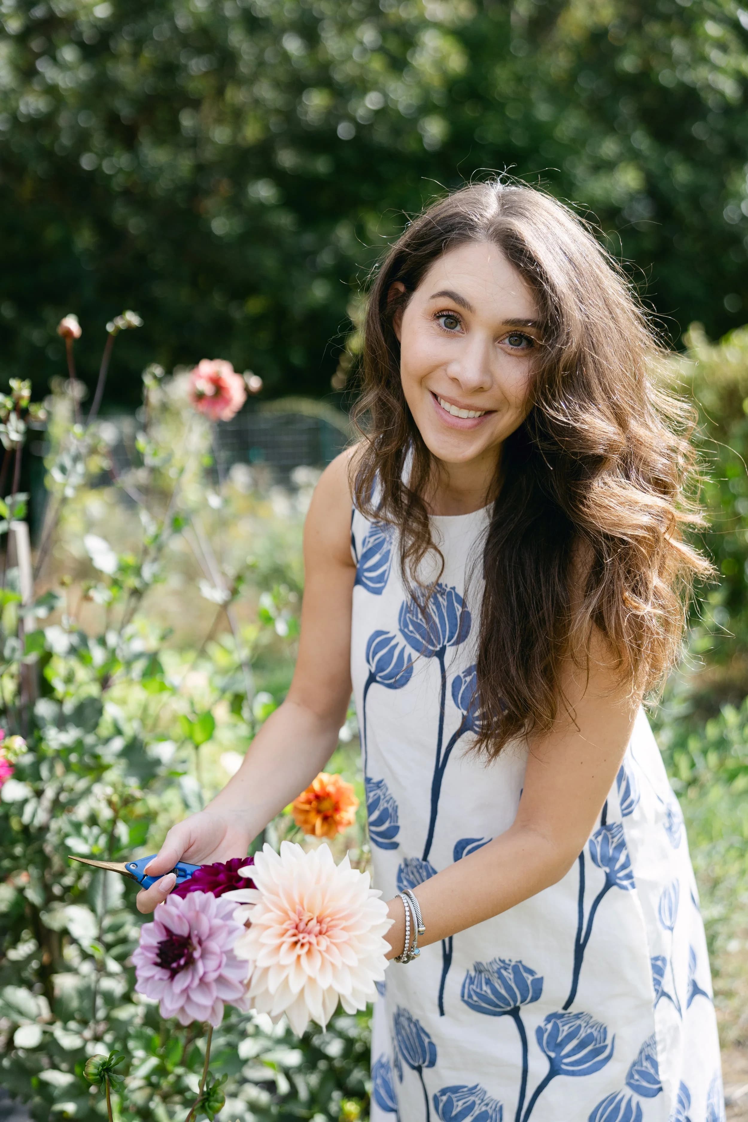 Bethie smiling in her garden, holding pruning shears